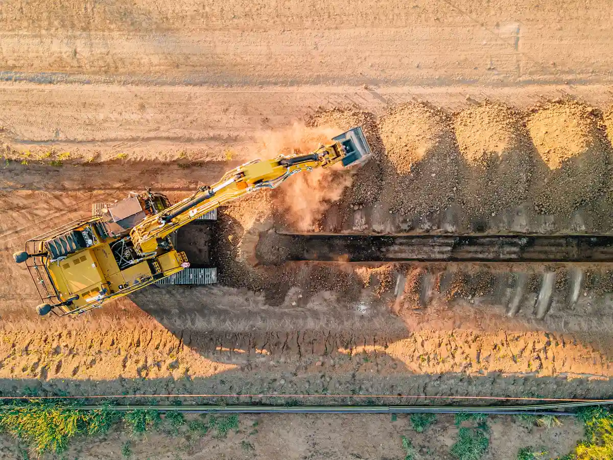 Excavator digging french drain trench in McDonough GA